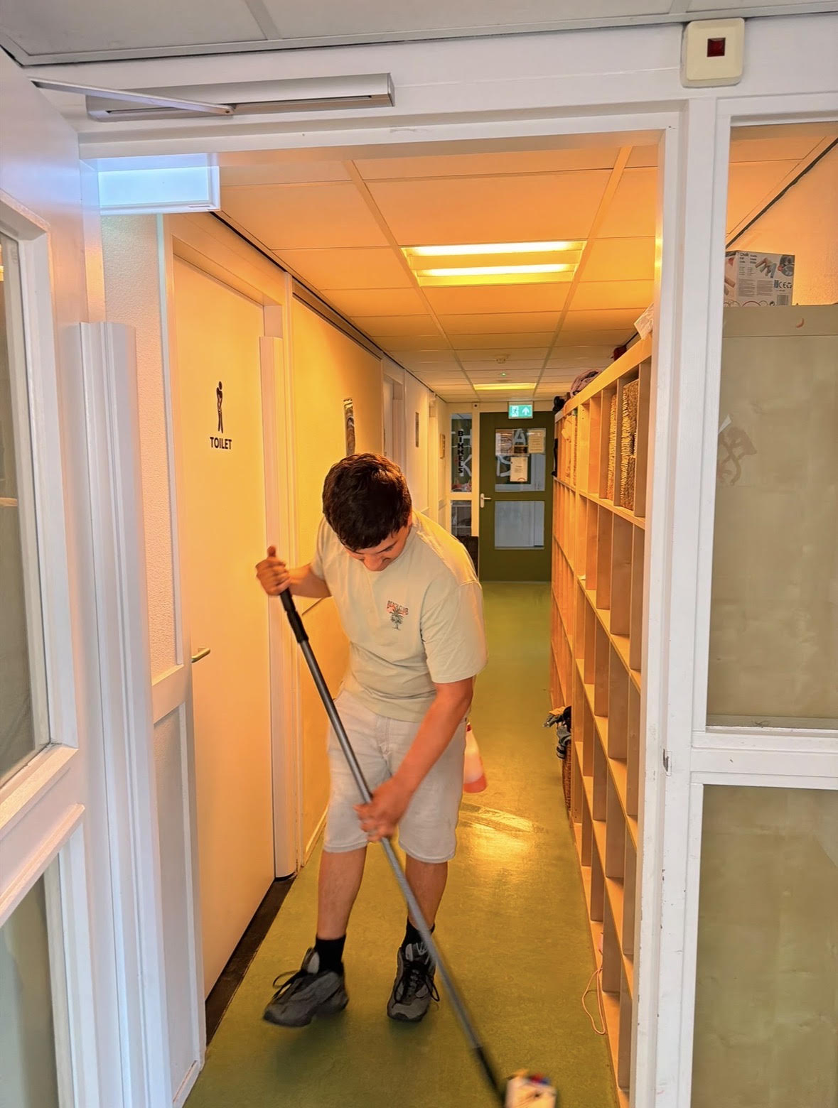 Schoonmaker aan het werk in een gang in Groningen